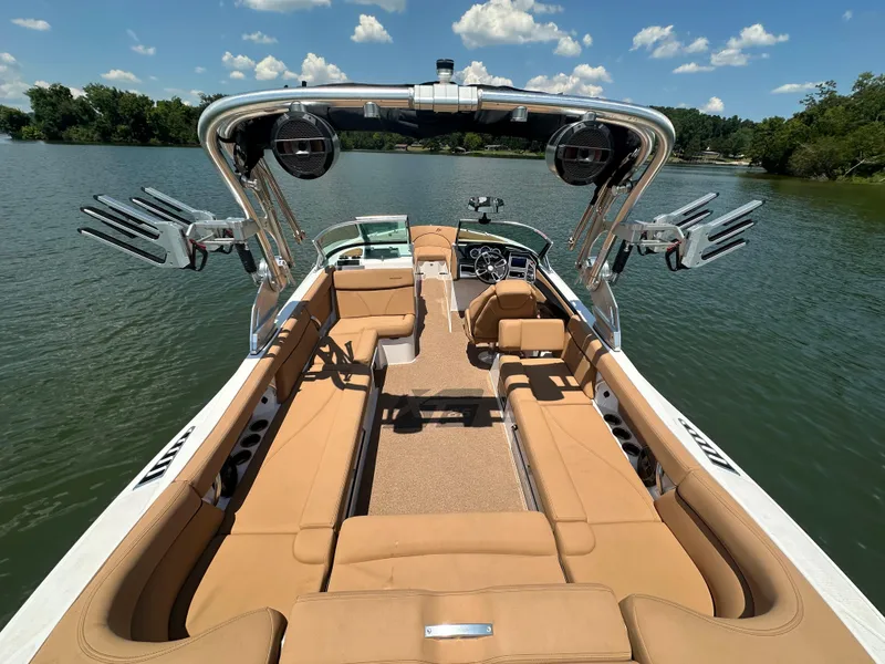 Slide: The Image of 2021 MasterCraft XT25 boat interior on a lake with clear skies. - 13