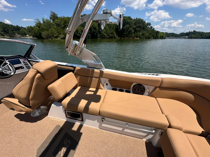 Slide: The Image of 2021 MasterCraft XT25 boat interior with tan leather seats on a lake. - 15
