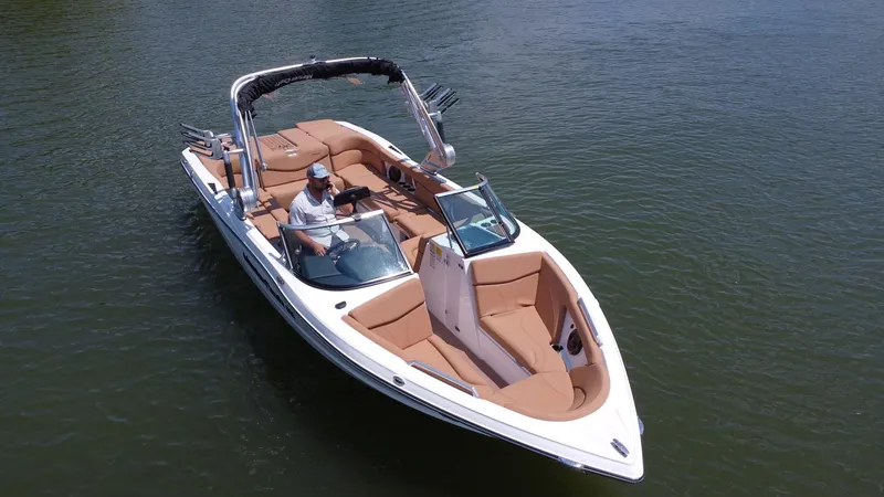 Slide: The Image of 2021 MasterCraft XT25 boat on water, featuring tan seating and a sleek design. - 5