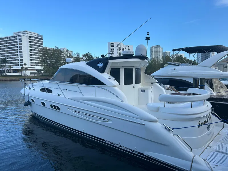 The Image of 2006 Neptunus 55 Cabrio yacht docked in a marina with cityscape background. - 0
