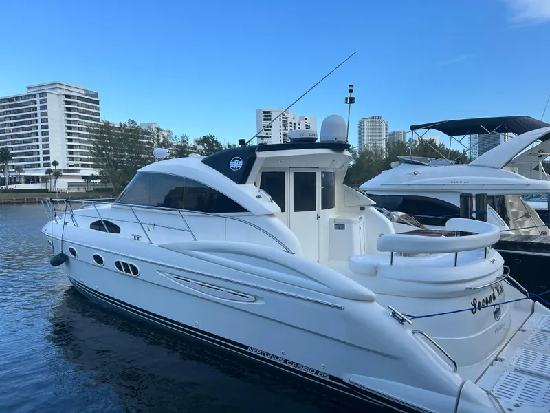 Slide: The Image of 2006 Neptunus 55 Cabrio yacht docked in marina with cityscape background. - 3