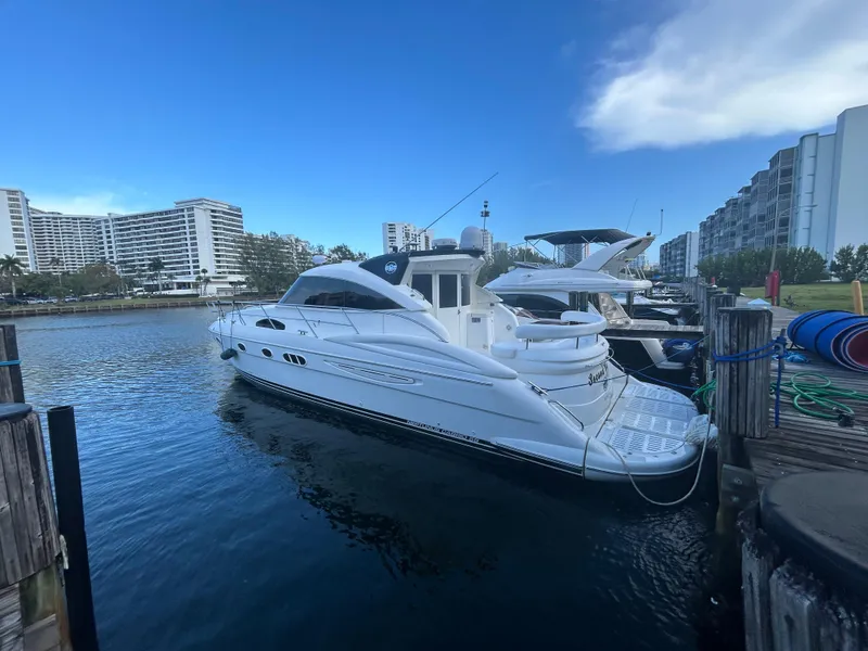 Slide: The Image of Luxury 2006 Neptunus 55 Cabrio yacht docked in a marina with modern buildings. - 4