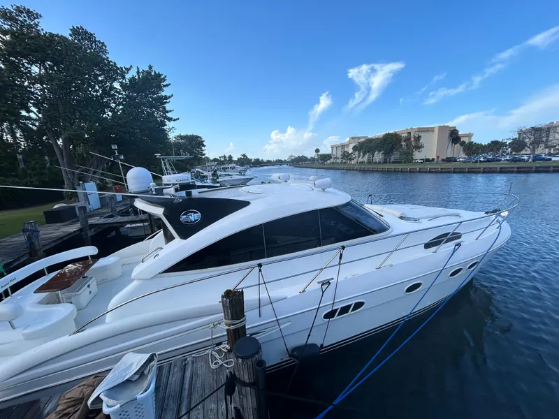 Slide: The Image of 2006 Neptunus 55 Cabrio yacht docked by a scenic waterfront. - 5