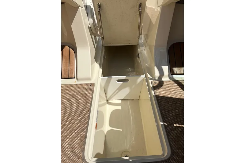 Slide: The Image of 2018 Chris-Craft Launch 23 boat storage compartment with open lid, showcasing interior space. - 11