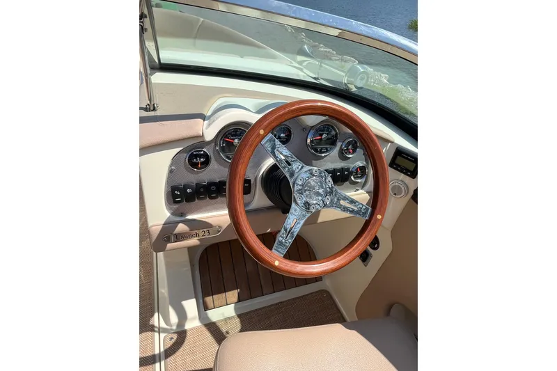 Slide: The Image of 2018 Chris-Craft Launch 23 boat dashboard with wooden steering wheel and gauges. - 18