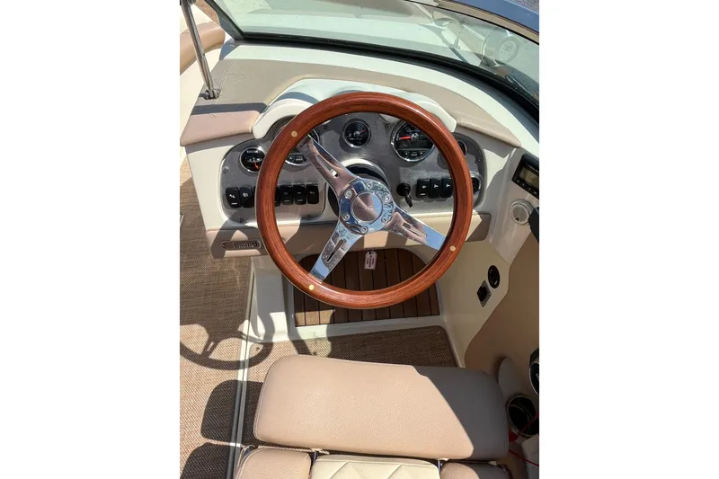 Slide: The Image of 2018 Chris-Craft Launch 23 dashboard with wooden steering wheel and instrument panel. - 19