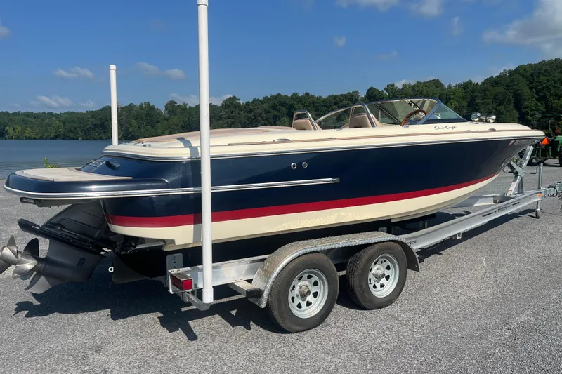 Slide: The Image of 2018 Chris-Craft Launch 23 boat on trailer by a lake, sunny day. - 2