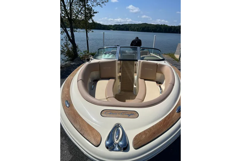 Slide: The Image of 2018 Chris-Craft Launch 23 boat with elegant seating, docked by a serene lake. - 24