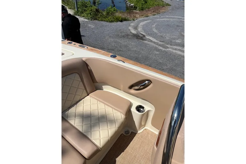Slide: The Image of 2018 Chris-Craft Launch 23 boat interior with beige leather seating and chrome accents. - 8