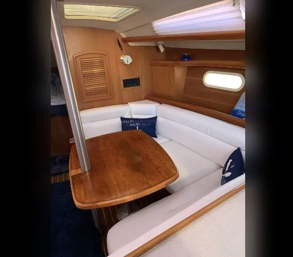 Slide: The Image of Interior of 2005 Hunter Mariner 36 yacht with wooden table and white seating. - 6