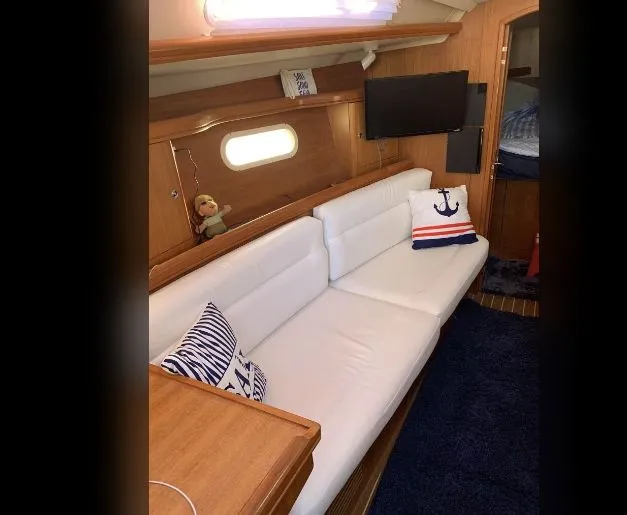 Slide: The Image of Interior of a 2005 Hunter Mariner 36 yacht with white sofa and nautical pillows. - 7