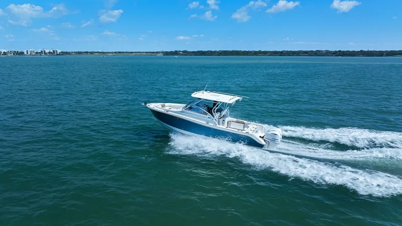 Slide: The Image of 2018 Edgewater 280CX Crossover on open sea under sunny skies. - 14