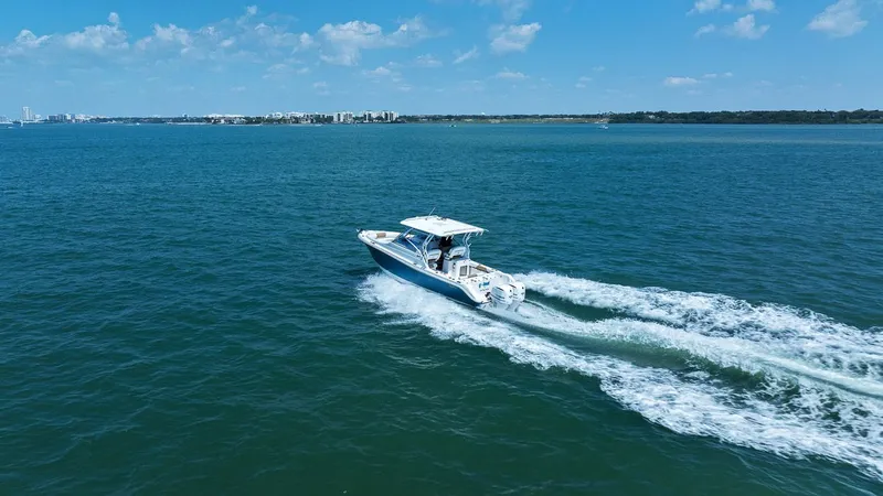 Slide: The Image of Edgewater 280CX Crossover 2018 cruising on open sea under sunny skies. - 21