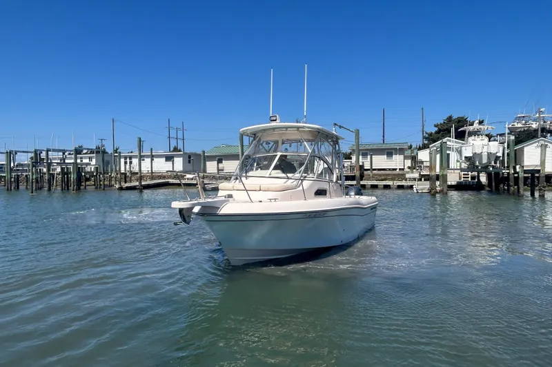 Slide: The Image of 2021 Grady-White Gulfstream 232 boat docked in a marina under clear blue skies. - 10