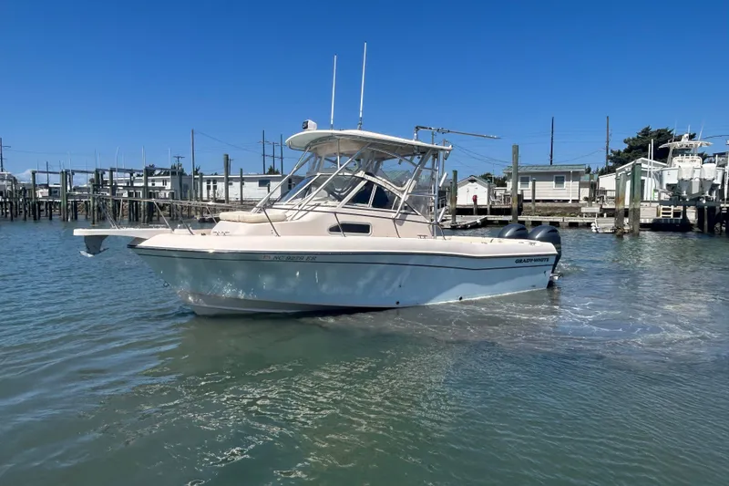 Slide: The Image of 2021 Grady-White Gulfstream 232 boat docked in a marina under clear blue skies. - 12