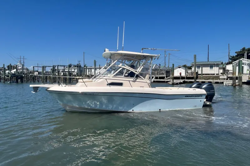 Slide: The Image of 2021 Grady-White Gulfstream 232 boat docked in a marina under clear blue skies. - 13