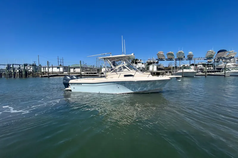 Slide: The Image of 2021 Grady-White Gulfstream 232 boat docked in marina under clear blue sky. - 2