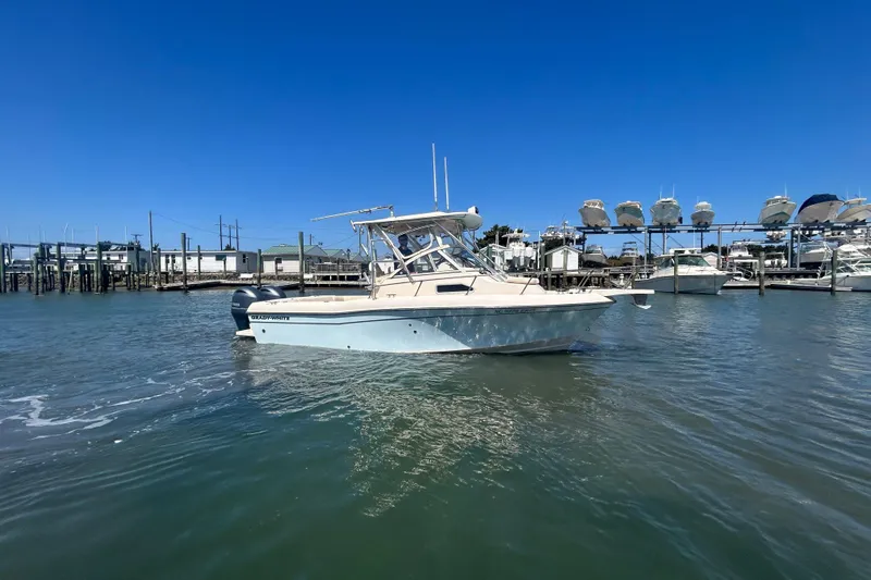 Slide: The Image of 2021 Grady-White Gulfstream 232 boat on water near marina under clear blue sky. - 3