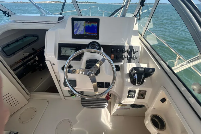 Slide: The Image of Grady-White Gulfstream 232 boat cockpit with steering wheel and navigation equipment, 2021 model. - 30