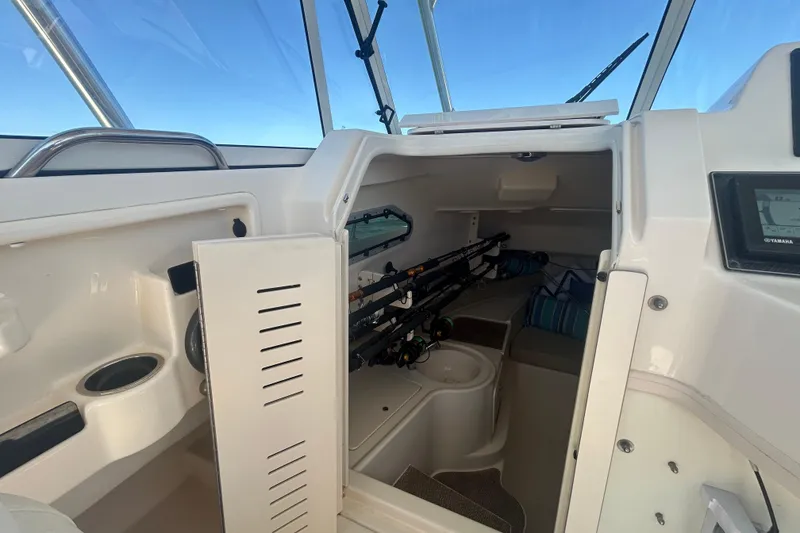 Slide: The Image of Interior view of 2021 Grady-White Gulfstream 232 boat cabin with fishing rods and seating. - 38