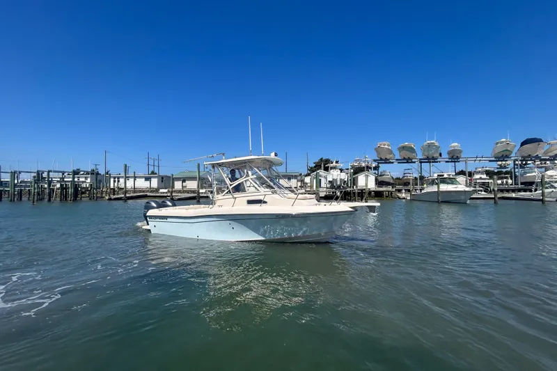 Slide: The Image of 2021 Grady-White Gulfstream 232 boat on water near marina under clear blue sky. - 4