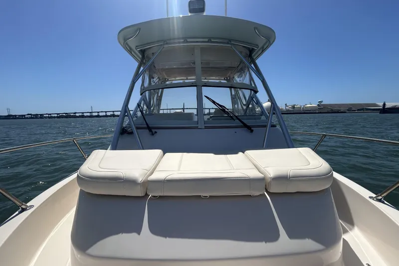 Slide: The Image of 2021 Grady-White Gulfstream 232 boat on water, featuring cushioned seating and clear skies. - 49