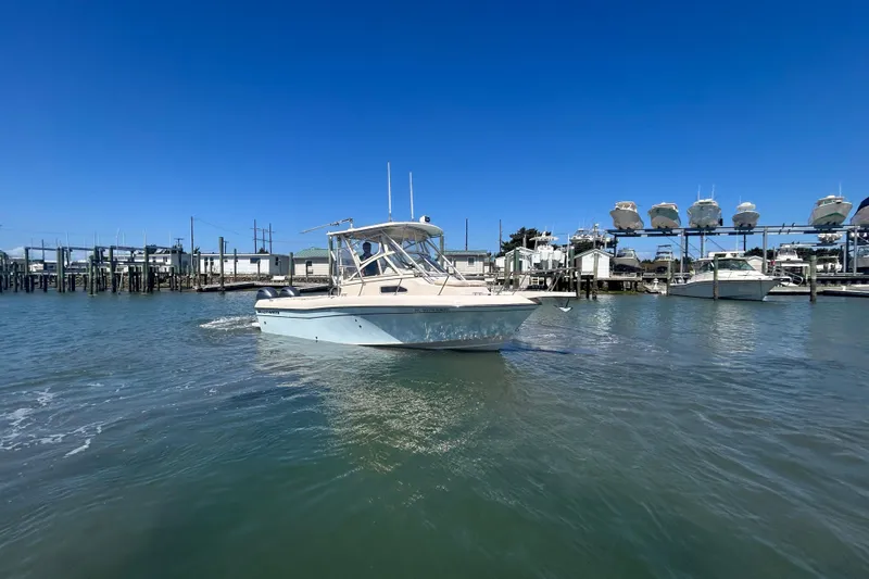 Slide: The Image of 2021 Grady-White Gulfstream 232 boat on water near marina under clear blue sky. - 5