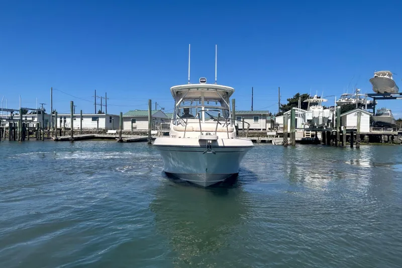 Slide: The Image of 2021 Grady-White Gulfstream 232 boat docked in a marina under clear blue skies. - 8