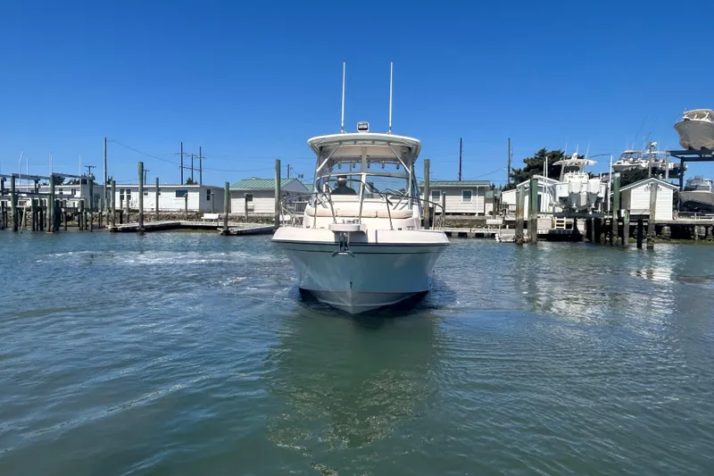 Slide: The Image of 2021 Grady-White Gulfstream 232 boat docked in a marina under clear blue skies. - 9