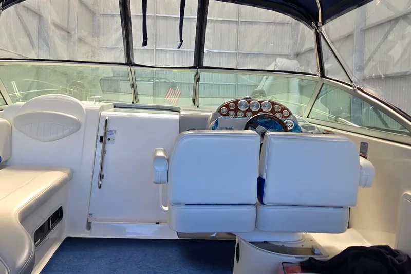 Slide: The Image of Interior of a 2007 Bayliner 325 boat with white seating and dashboard. - 13