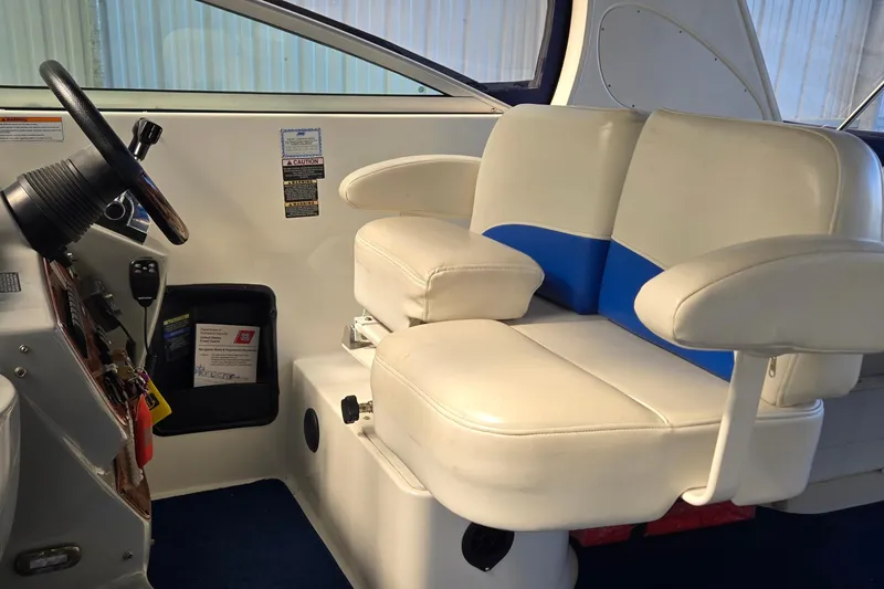 Slide: The Image of Captain's seat in 2007 Bayliner 325 boat, featuring white and blue upholstery. - 14