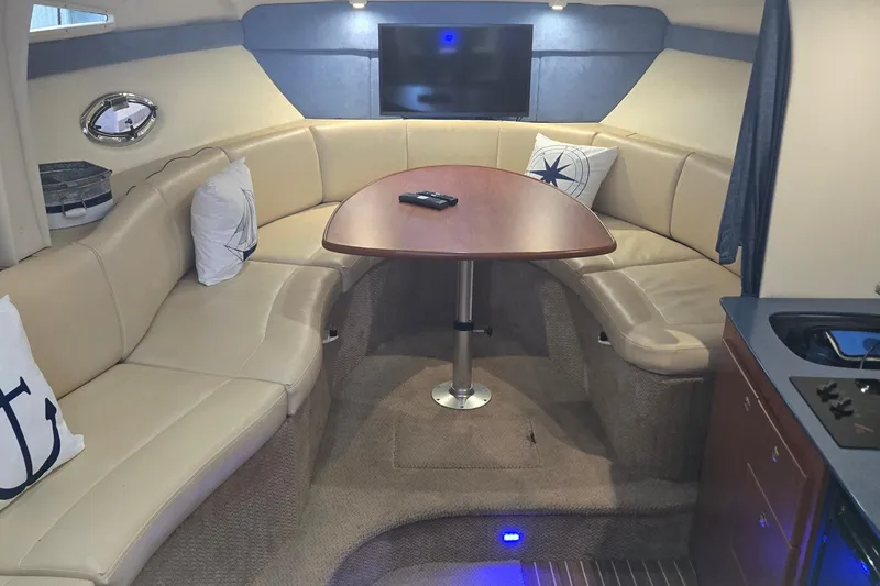 Slide: The Image of Interior of 2007 Bayliner 325 yacht with beige seating and wooden table. - 18