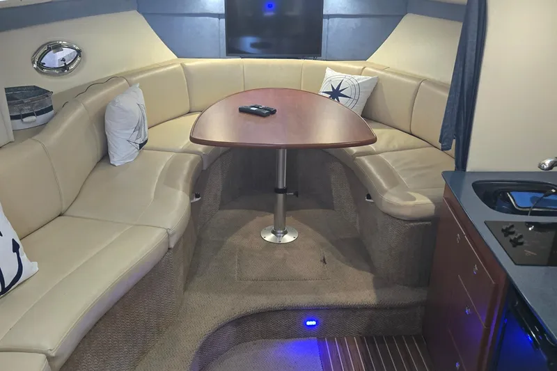 Slide: The Image of Interior of 2007 Bayliner 325 yacht with beige seating and wooden table. - 20