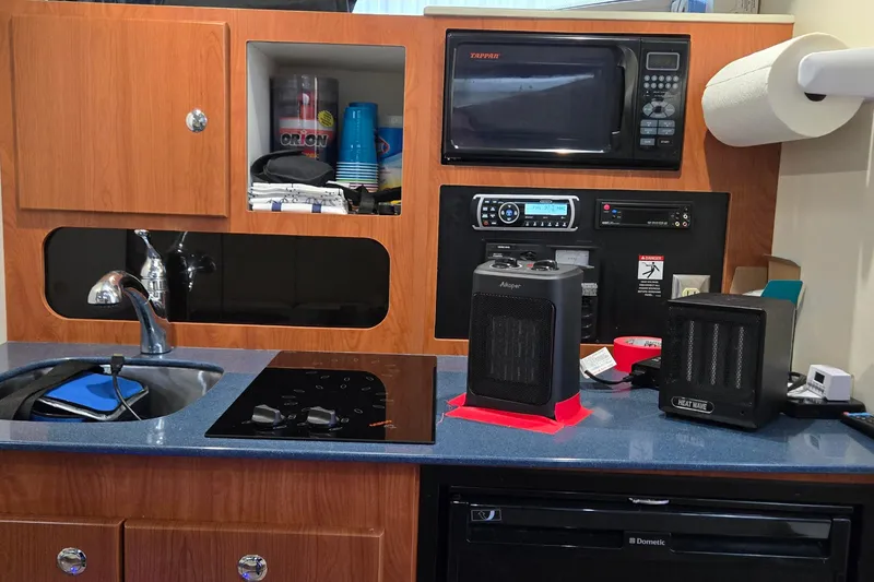 Slide: The Image of Compact kitchen area in a 2007 Bayliner 325 boat with appliances and heaters. - 26