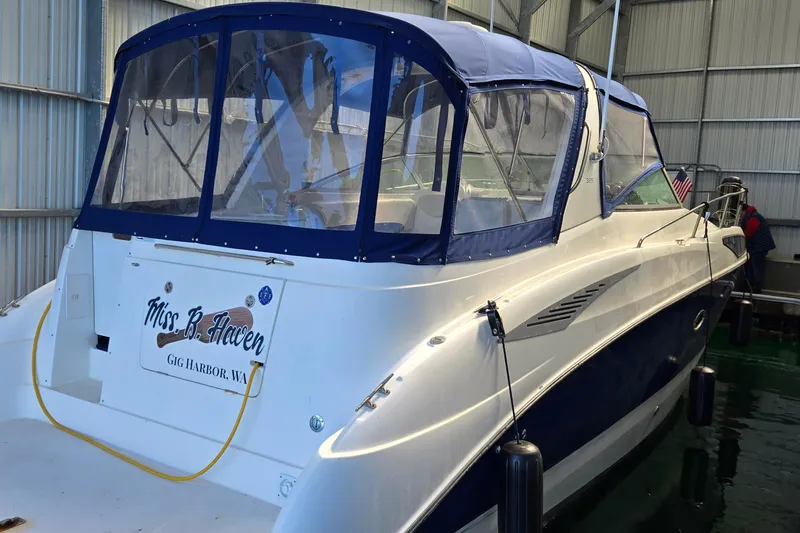 Slide: The Image of 2007 Bayliner 325 boat docked indoors, featuring blue canopy and "Miss B. Haven" nameplate. - 3