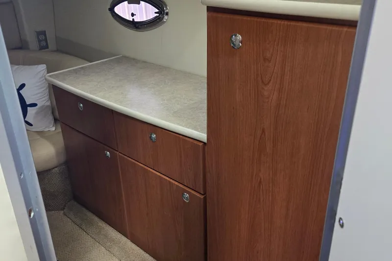 Slide: The Image of 2007 Bayliner 325 cabin interior with wood cabinetry and seating area. - 33