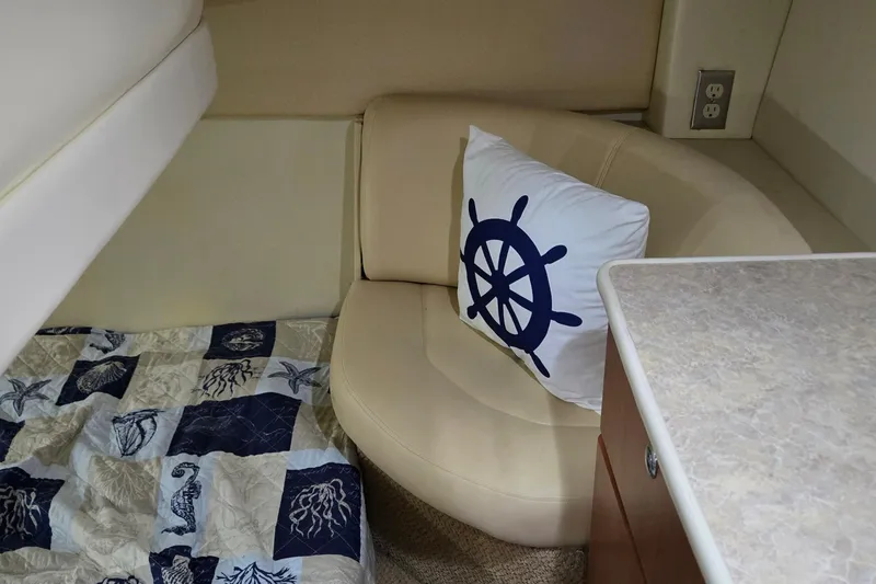 Slide: The Image of Interior of 2007 Bayliner 325 boat with nautical-themed decor and cozy seating. - 34