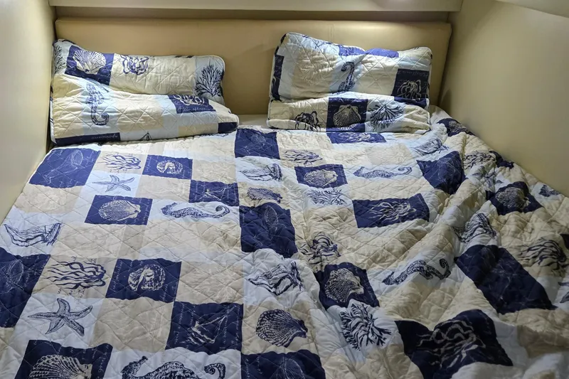 Slide: The Image of Cozy bed with nautical-themed bedding inside a 2007 Bayliner 325 boat cabin. - 35