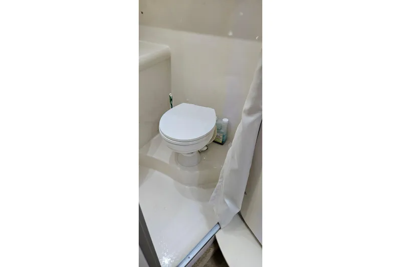 Slide: The Image of Compact bathroom in a 2007 Bayliner 325 boat, featuring a white toilet. - 38