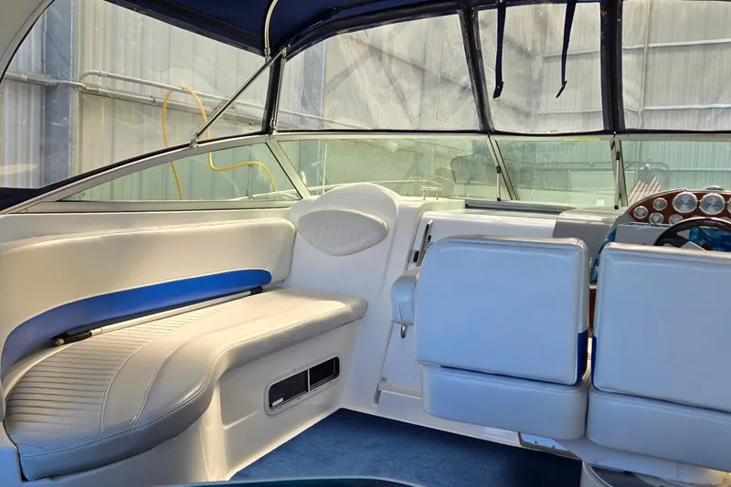 Slide: The Image of Interior of a 2007 Bayliner 325 boat with white seating and dashboard. - 7
