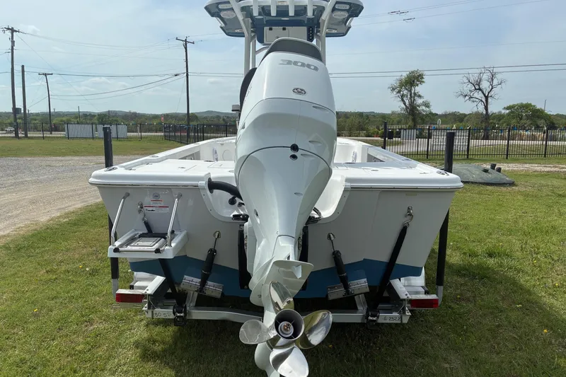 Slide: The Image of 2026 Sea Pro 250 Bay boat with powerful outboard motor, parked on grassy area. - 3