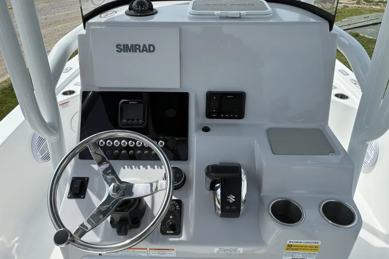 Slide: The Image of 2026 Sea Pro 250 Bay boat console with steering wheel and Simrad electronics. - 9