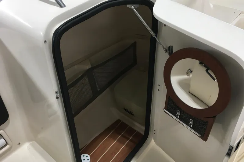 Slide: The Image of 2016 Grady-White Freedom 225 boat interior with storage compartment and wooden flooring. - 10