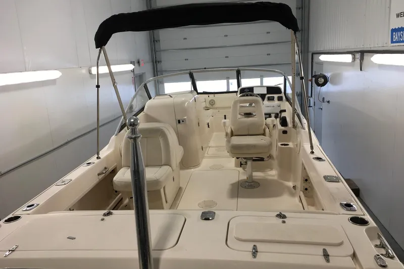 Slide: The Image of 2016 Grady-White Freedom 225 boat interior with seating and controls in a garage. - 7