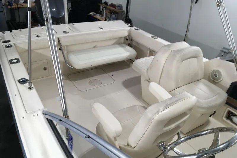 Slide: The Image of 2016 Grady-White Freedom 225 boat interior with white seating and steering wheel. - 8