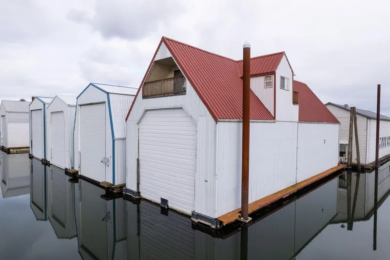 The Image of Floating boathouses with red roofs and white walls, reflecting on calm water, 1976 Custom model. - 0