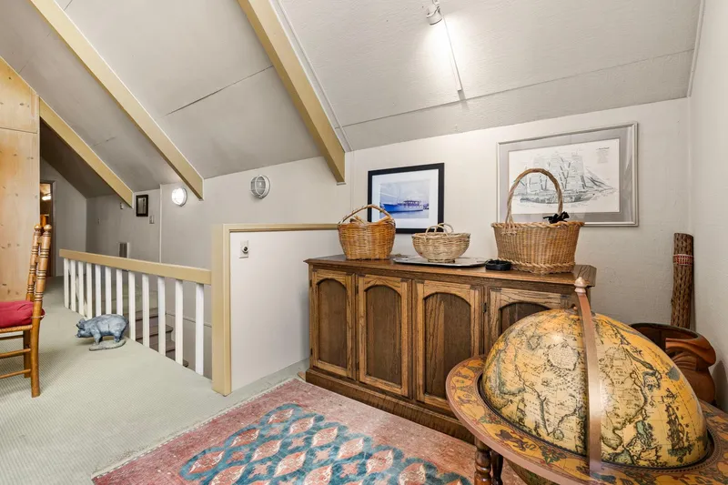 Slide: The Image of Cozy boathouse interior with vintage decor, globe, wicker baskets, and nautical artwork, built in 1976. - 11