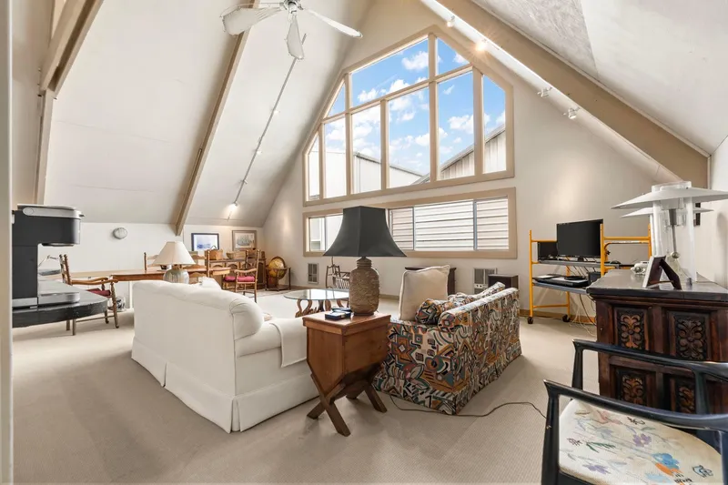 Slide: The Image of Spacious 1976 custom boathouse interior with vaulted ceilings, large windows, and eclectic furnishings. - 13