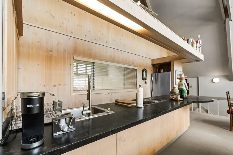 Slide: The Image of Modern kitchen in 1976 custom boathouse with sleek countertops and Keurig coffee maker. - 14