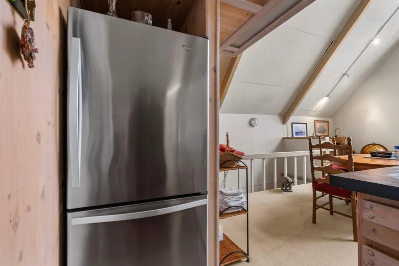 Slide: The Image of Cozy boathouse interior with stainless steel fridge, wooden beams, and dining area, built in 1976. - 17